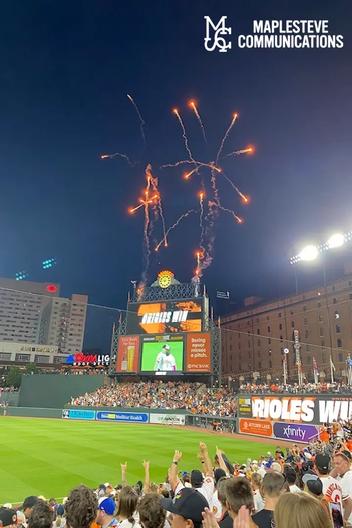 Fireworks are being lit at a baseball game.